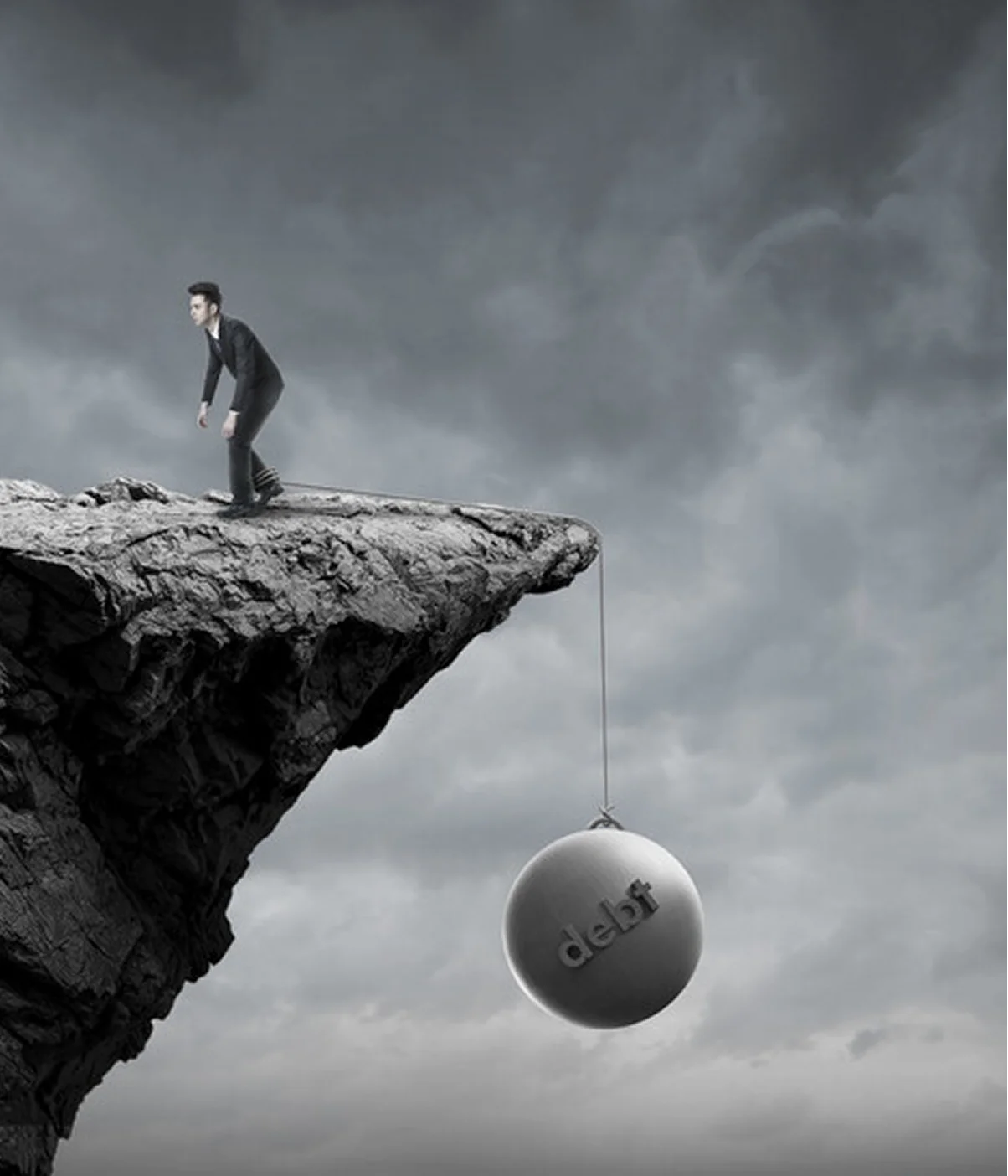 Person on cliff edge with debt burden